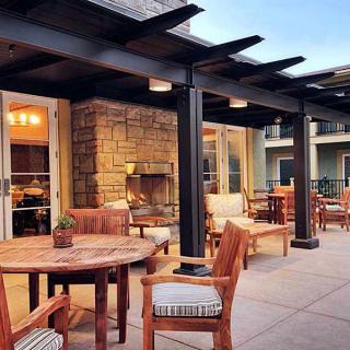 A cozy outdoor patio with wooden furniture and a pergola, perfect for evening gatherings.
