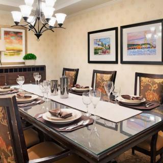 An elegant dining room with a beautifully set table and tasteful artwork on the walls.