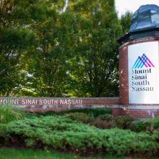 Welcome sign for Mount Sinai South Nassau, surrounded by greenery.