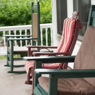 Wooden deck with cushioned chairs for relaxing.