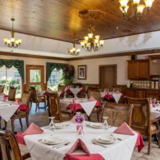 A well-decorated dining room with elegantly set tables and classic chandeliers.