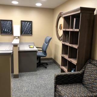 A small office space with a desk, chair, and bookshelf.