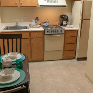 Cozy apartment kitchen with dining area and basic appliances.