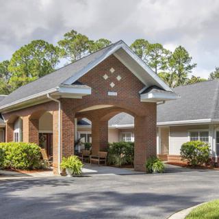 A brick building with a covered entrance and well-maintained landscaping.