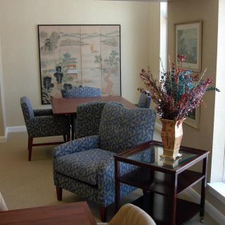 An office space with comfortable seating, artwork on the walls, and a decorative plant.