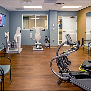 A well-equipped physical therapy gym featuring various exercise machines and a welcoming atmosphere.