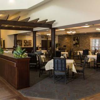 An elegant dining area with neatly arranged tables and chairs, accentuated by warm lighting and decor.