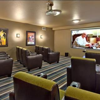 A cozy home theater setup with comfortable recliners and a large screen for movie viewing.