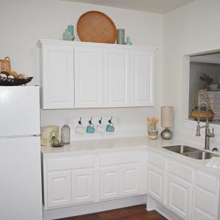 A modern kitchen with white cabinets and minimalist decor.