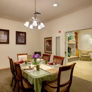 A cozy dining room with a neatly set table and elegant lighting.