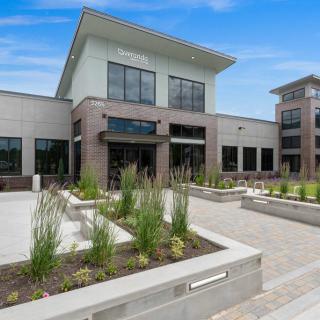 A modern office building with a landscaped outdoor area on a sunny day.