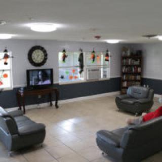 A cozy living room with sofas, a TV, and a bookshelf.