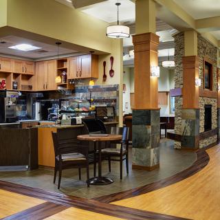 A cozy coffee shop interior with modern design elements and a seating area near the kitchen.