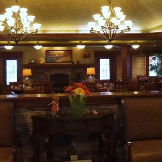 A cozy lobby with warm lighting, comfortable seating, and elegant chandeliers.