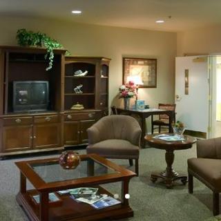 A cozy living room with comfortable seating, a wooden cabinet holding a television, and a coffee table.