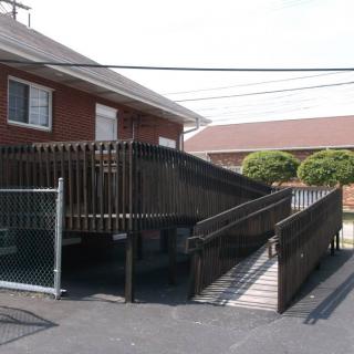 An outdoor wheelchair ramp providing accessibility to a brick building.