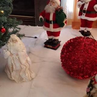 Festive Christmas decorations featuring Santa Claus figurines and a large red ornament.
