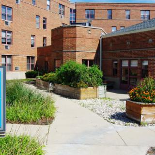 A brick building with landscaped pathways and garden beds.