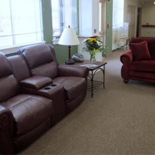 A cozy living room with leather and fabric sofas, a lamp, and a side table.