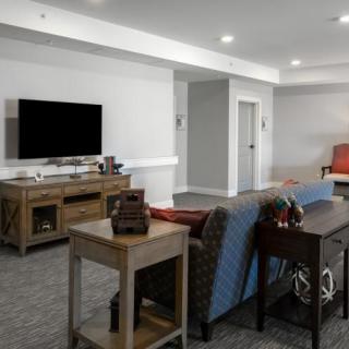 A modern living room featuring a comfortable sofa, a flat-screen television, and stylish furniture.