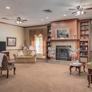 A cozy living room with a fireplace, bookshelves, and comfortable seating.
