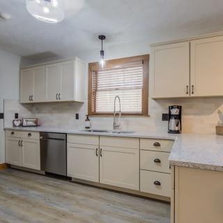 A modern kitchen with light-colored cabinets, stainless steel appliances, and a spacious countertop.