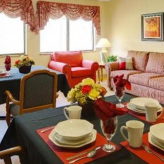 A cozy living and dining area featuring a table set for four, with comfortable seating and decorative elements.