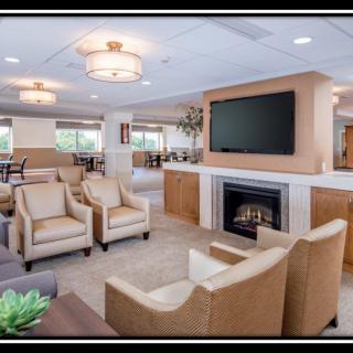 A modern living room with comfortable seating, a fireplace, and a large television.