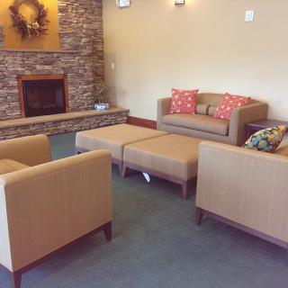A cozy living room with sofas and chairs arranged around a fireplace.