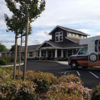 A van parked in front of a large building on a cloudy day.