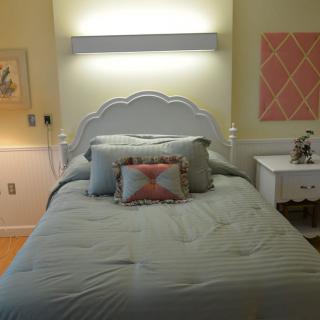 Cozy bedroom with decorative pillows and wall art.
