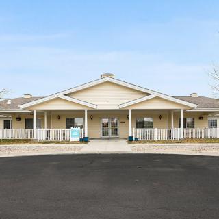 A front view of a large residential building with a porch and entrance.