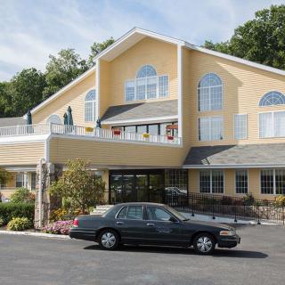 A hotel exterior with a car parked in front.