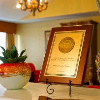 A framed award plaque displayed on a stand in a warmly lit room.