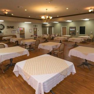 A spacious dining area with neatly arranged tables and chairs, adorned with white tablecloths.