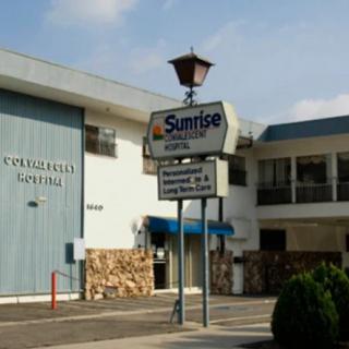 Exterior view of a motel with a prominent sign for Sunrise Inn.