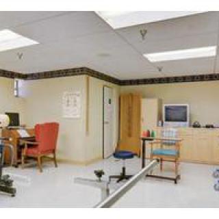 A well-equipped office space with a computer desk, bookshelves, and exercise equipment.