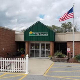 The entrance of a facility featuring a green roof and an American flag.