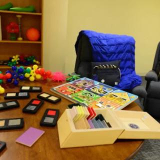A therapy room equipped with sensory toys, educational puzzles, and relaxation chairs for children.