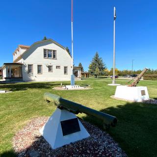 An outdoor military exhibit featuring artillery pieces at a historic museum on a sunny day.