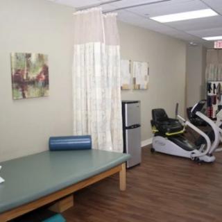 A physical therapy clinic featuring a treatment area and exercise equipment.