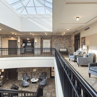A modern lobby area with comfortable seating and a large skylight.