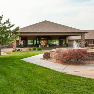 A modern building with a fountain surrounded by well-maintained greenery.