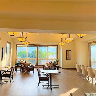 A bright and inviting dining area with large windows and elegant chandeliers.
