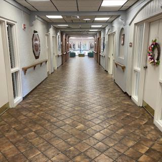A spacious, well-lit hallway with tiled flooring and decorated doors.