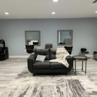 A modern and minimalist living room with a cozy sofa, mirrors on the wall, and a stylish decor.