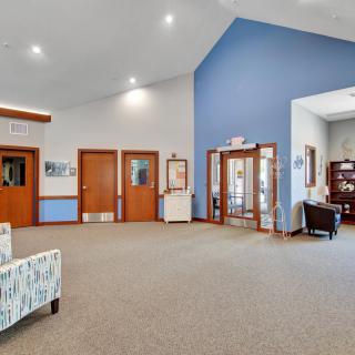 A spacious lobby area with seating and wooden doors, featuring a welcoming atmosphere.