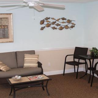 A cozy living room with a sofa, chairs, and artistic wall decorations.