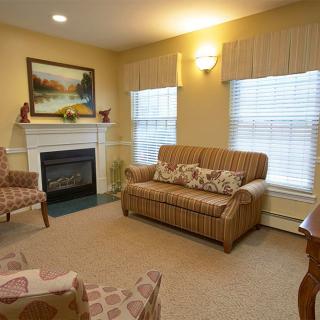 A cozy living room with a fireplace, sofa, and artwork.