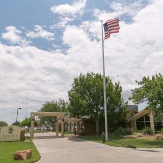 An entrance with an American flag flying on a cloudy day.